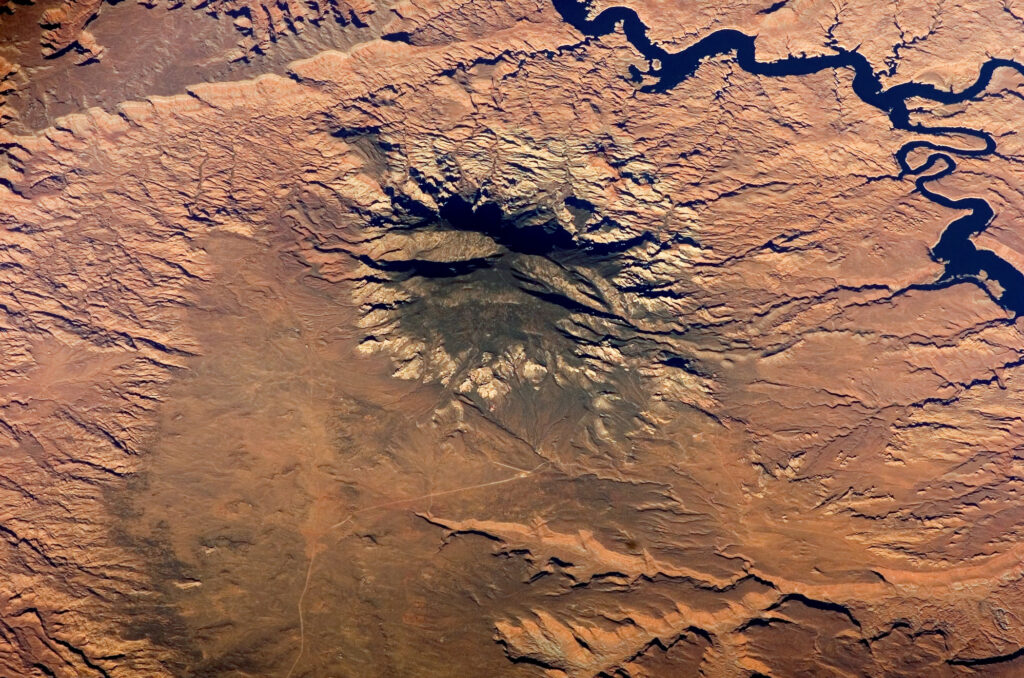 Navajo Mountain in southern Utah, seen from space as an isolated peak surrounded by the flat, layered landscape of the Colorado Plateau.