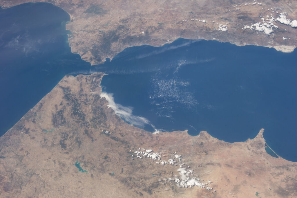 A clear view of the Strait of Gibraltar from space, showing Spain to the north and Morocco to the south, with the Atlantic Ocean flowing into the Mediterranean Sea.